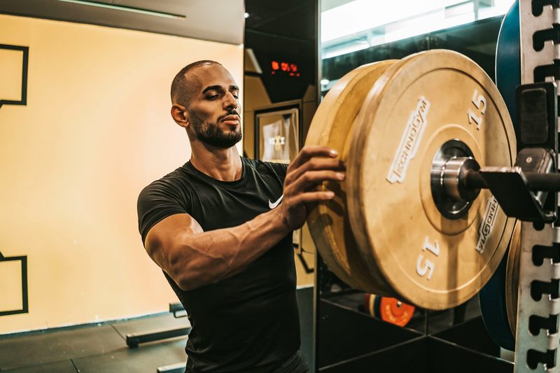 Man putting weight on a rack in the gym