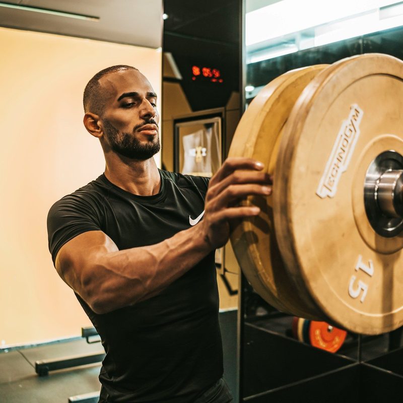 Man putting weight on a rack in the gym