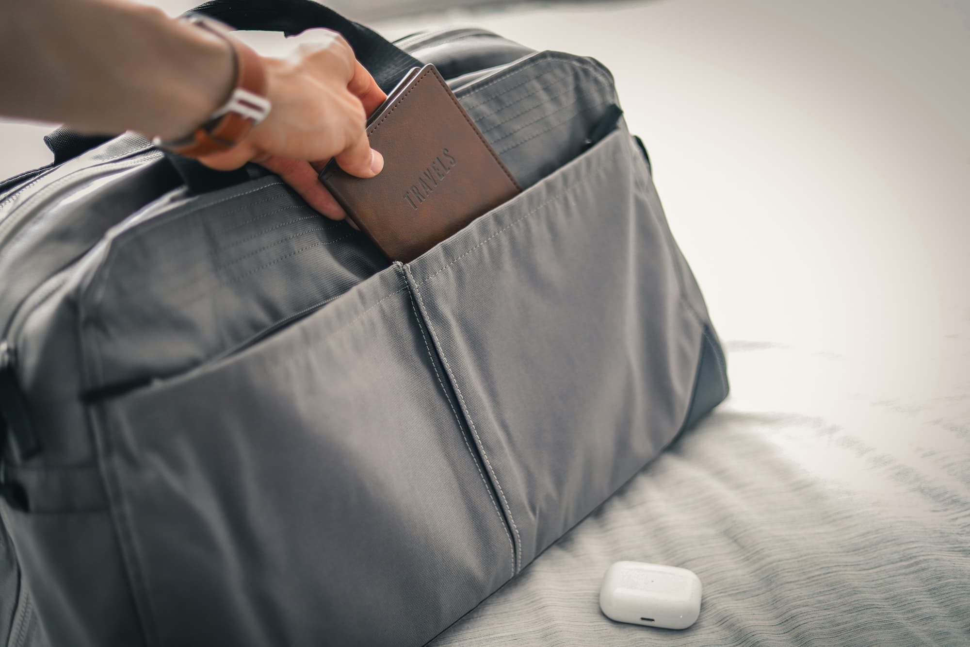 a person putting a passport in a bag