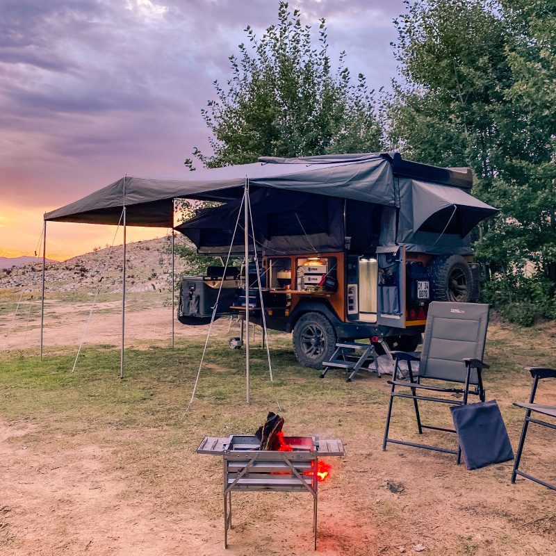 An Invader Duo X off-road camper setup in South Africa with its awning and camp chairs.