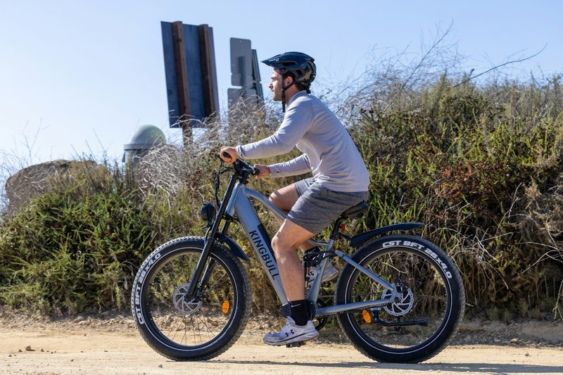 man riding bike bicycle with helmet on cycling outdoors blue sky
