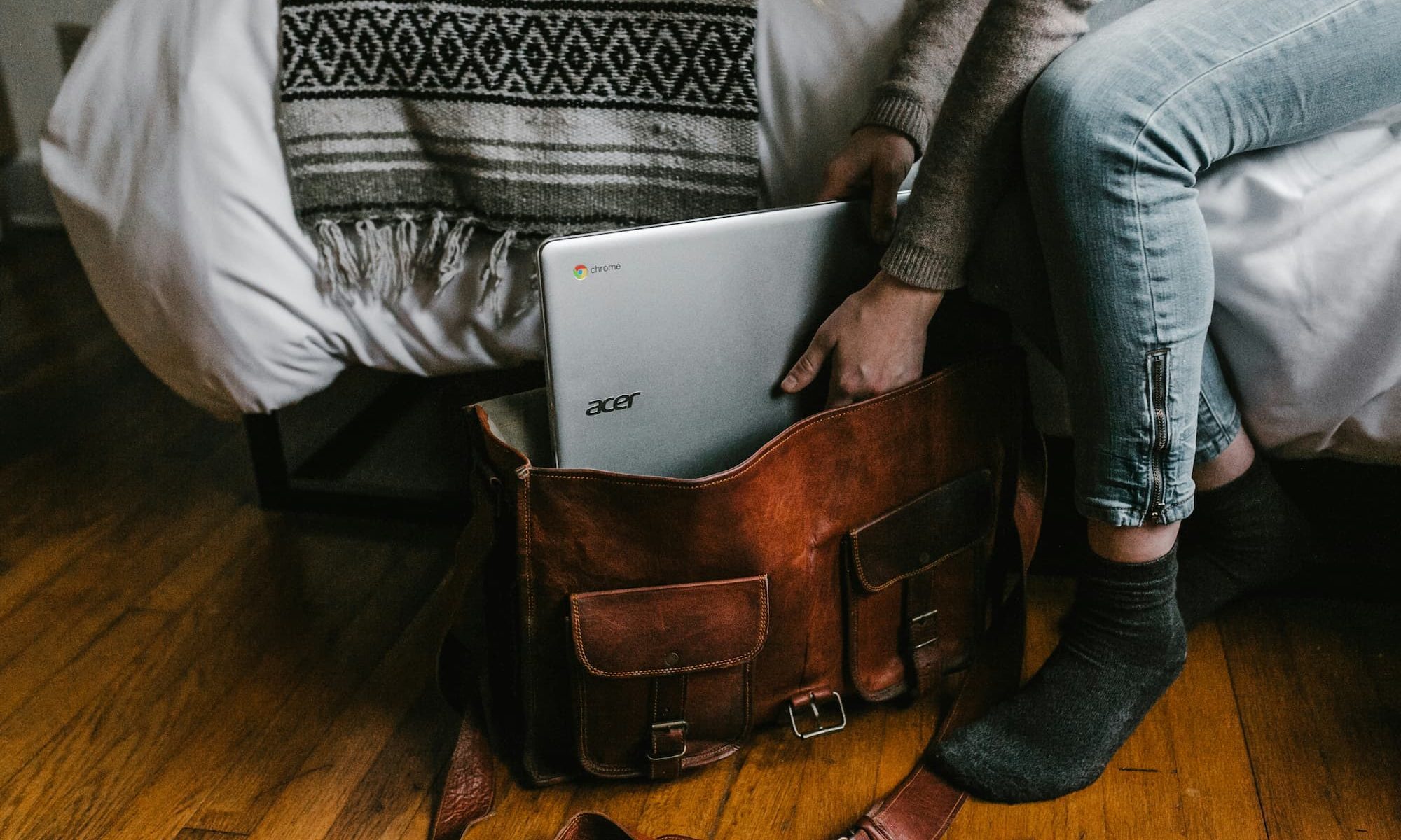 person packing a laptop in a bag