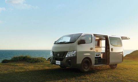 Nissan Caravan MyRoom campervan parked in a waterfront field.