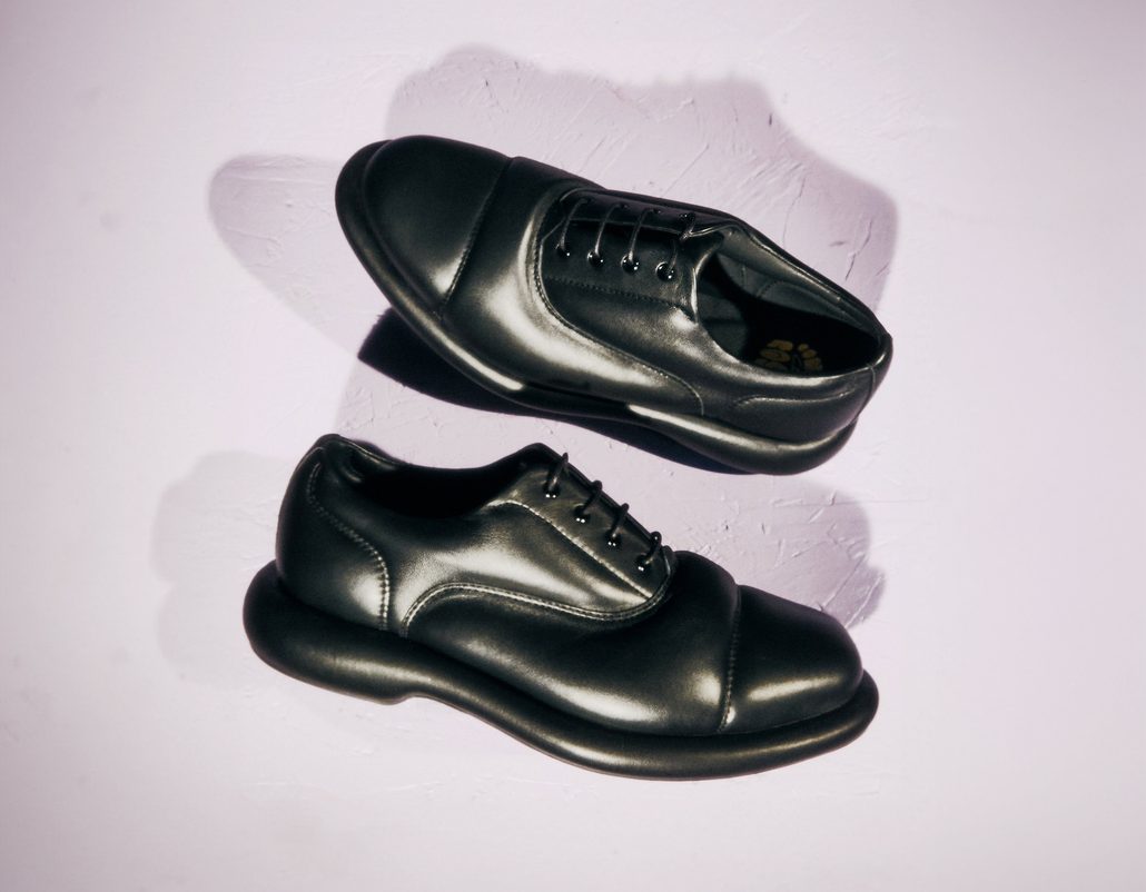 black padded oxford shoes on white table