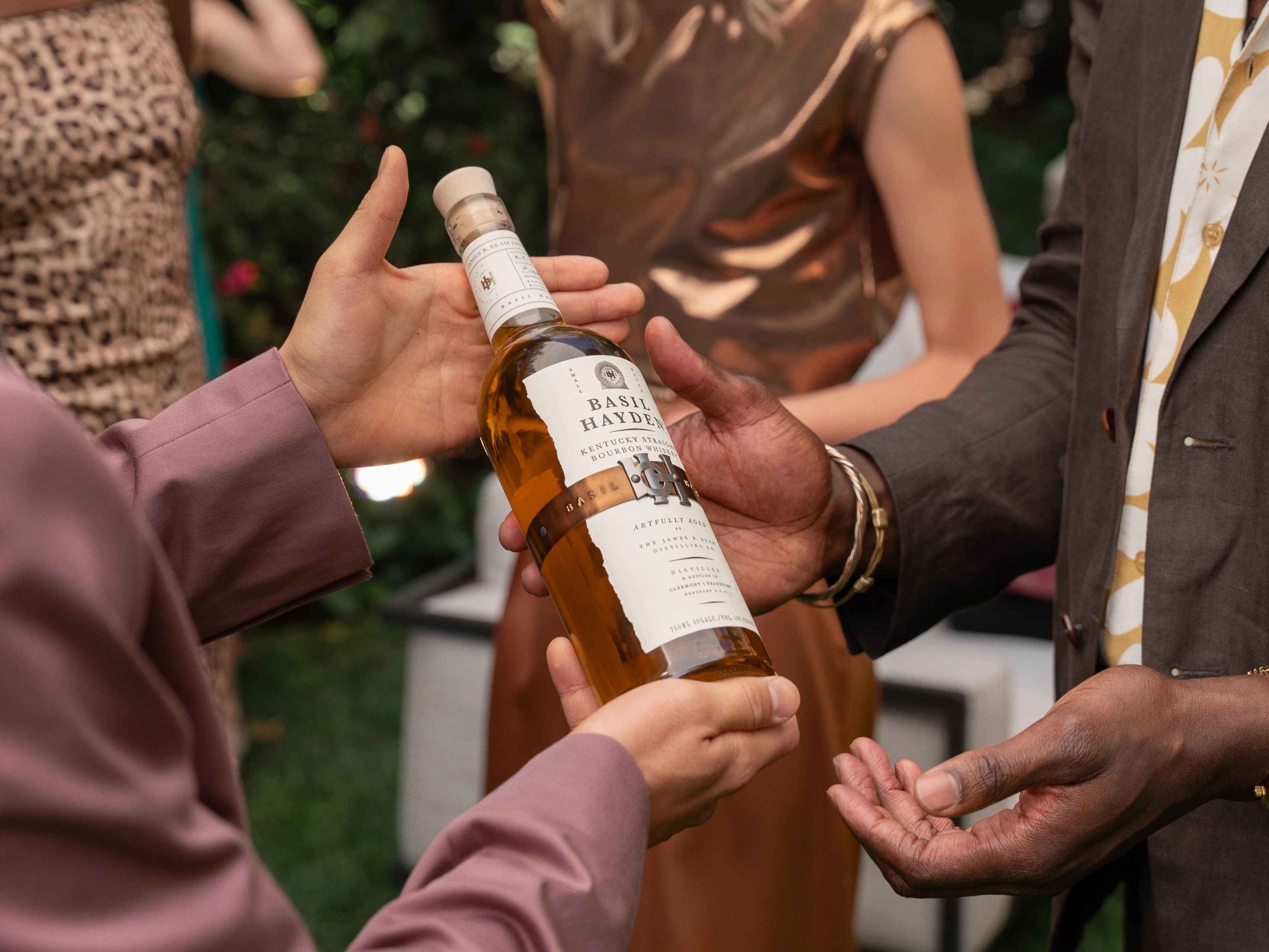 people sharing a bottle of Basil Hayden Kentuck Straight Bourbon Whiskey