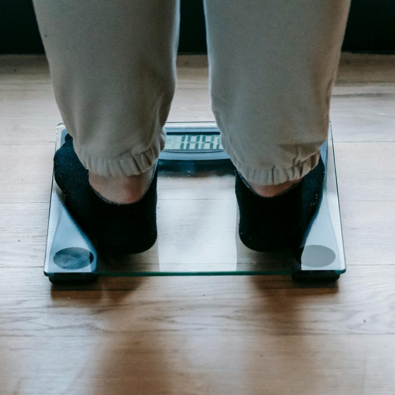 Man weighing himself on scale.