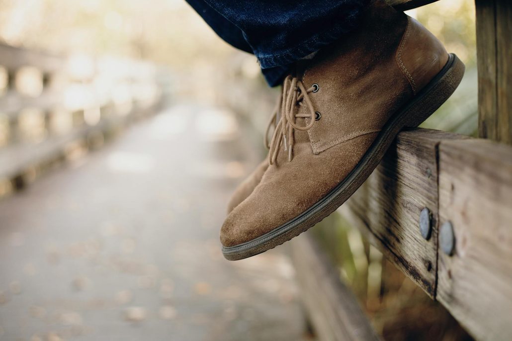 close up of person wearing chukka boots