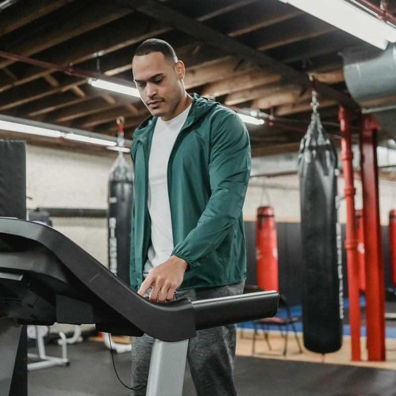 Man on treadmill walking using machine in gym