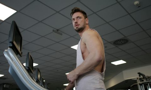 Man on treadmill with sleeveless shirt in gym