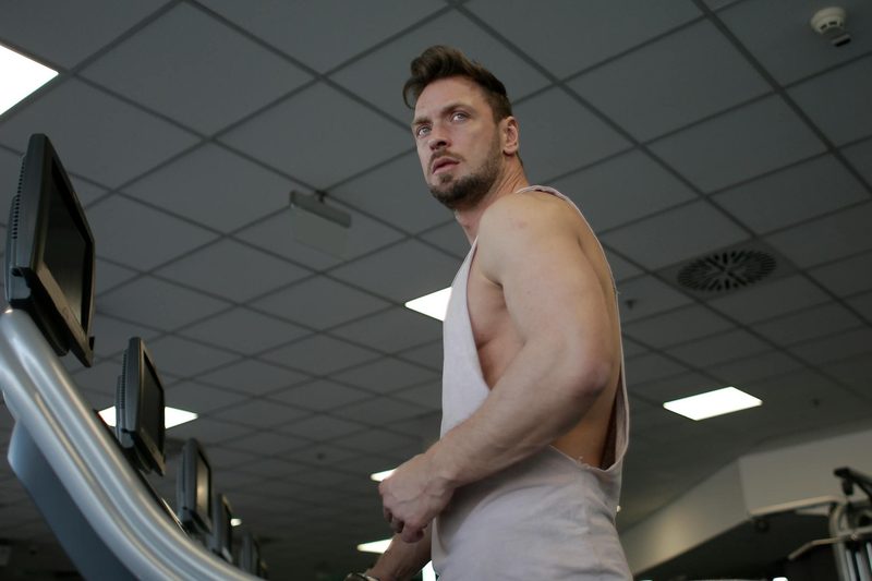 Man on treadmill with sleeveless shirt in gym