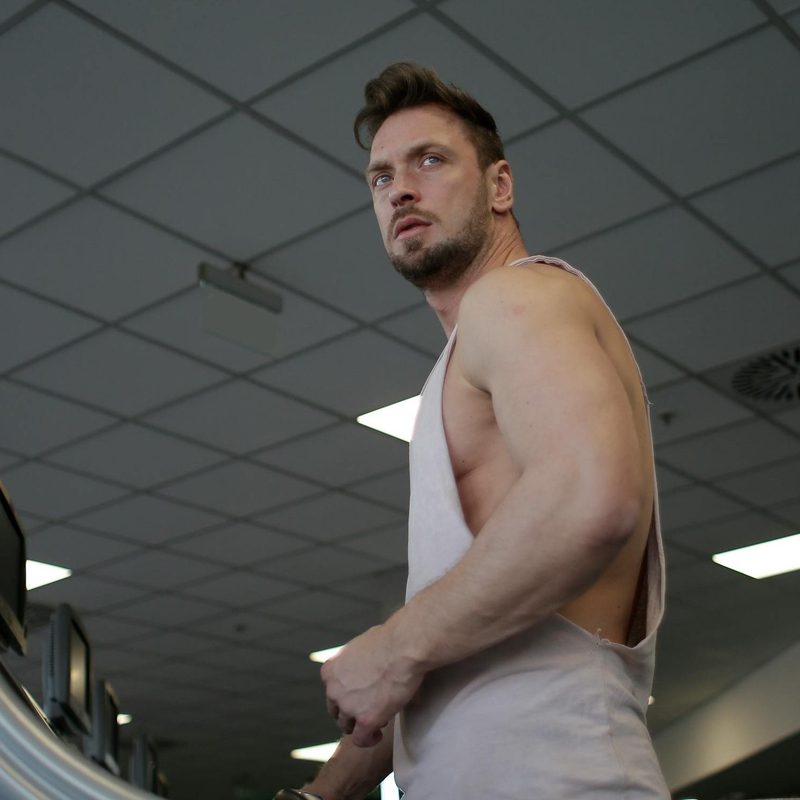 Man on treadmill with sleeveless shirt in gym