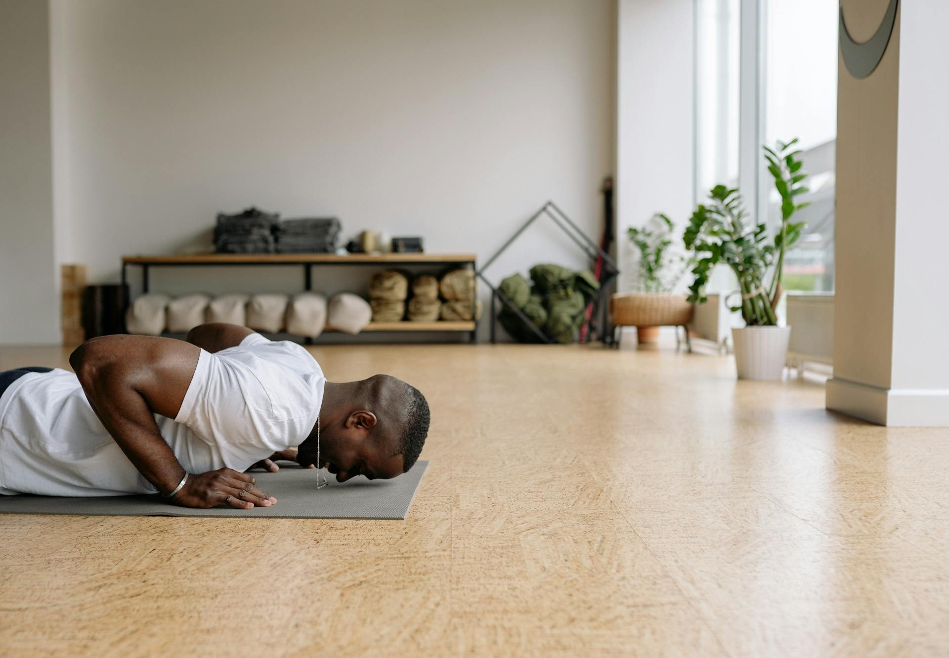 man doing push up on floor yoga mat in gym room wooden floor