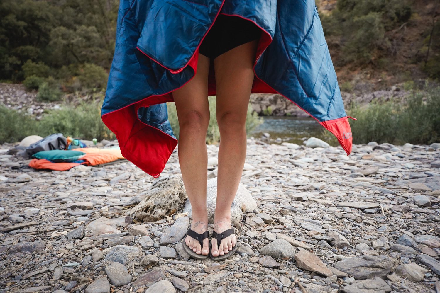 Lower shot of a person wearing Rumpl's Backcountry Puffy Blanket as a cape.