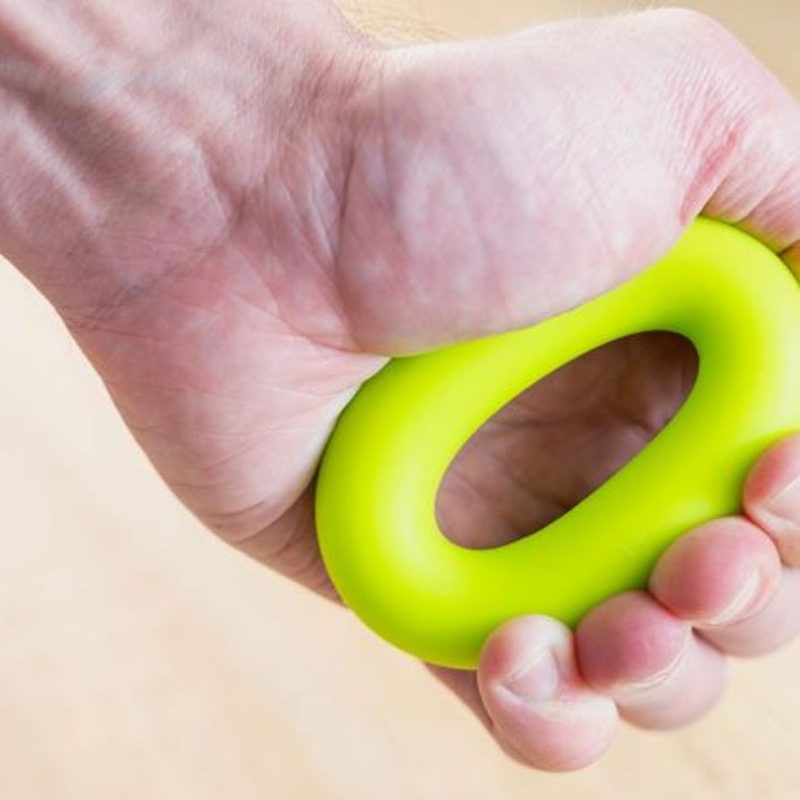 Man hand close-up squeezing the stress ball or grip strengthener