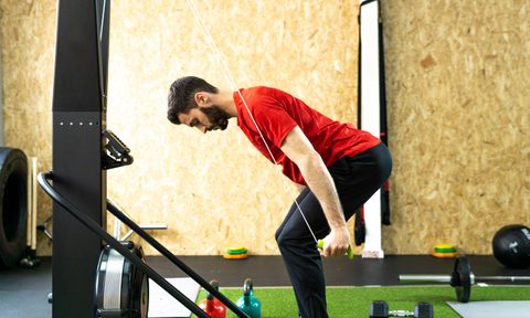 man with red shirt doing SkiErg machine skiing exercise equipment