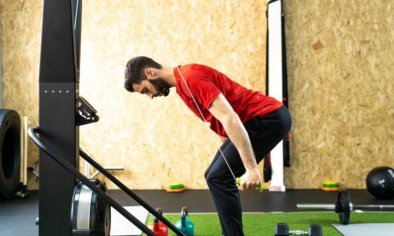 man with red shirt doing SkiErg machine skiing exercise equipment