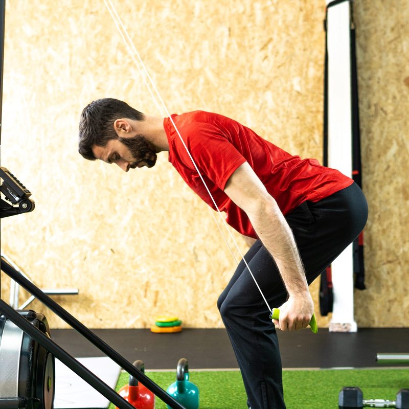 man with red shirt doing SkiErg machine skiing exercise equipment