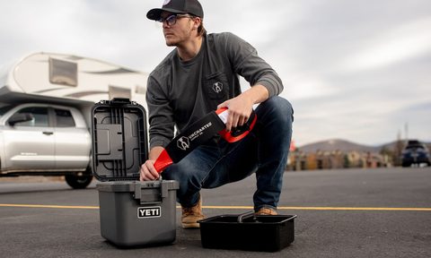 Man opening the Uncharted Supply x Yeti Overland overlanding kit.