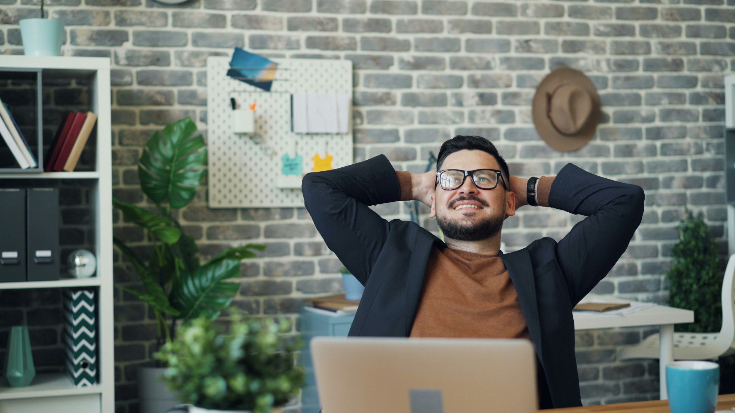 Man happy smiling at desk stretching arms positive