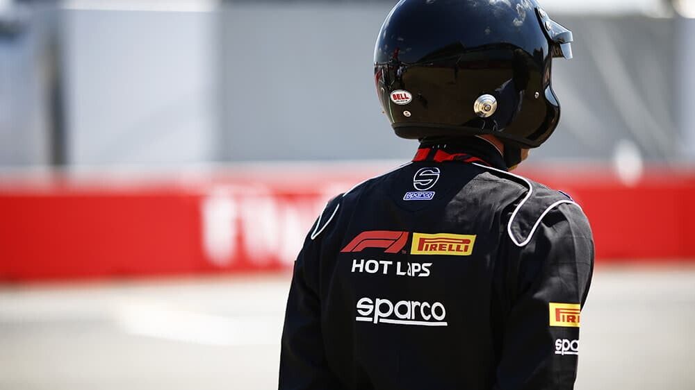 A driver in a hot laps firesuit