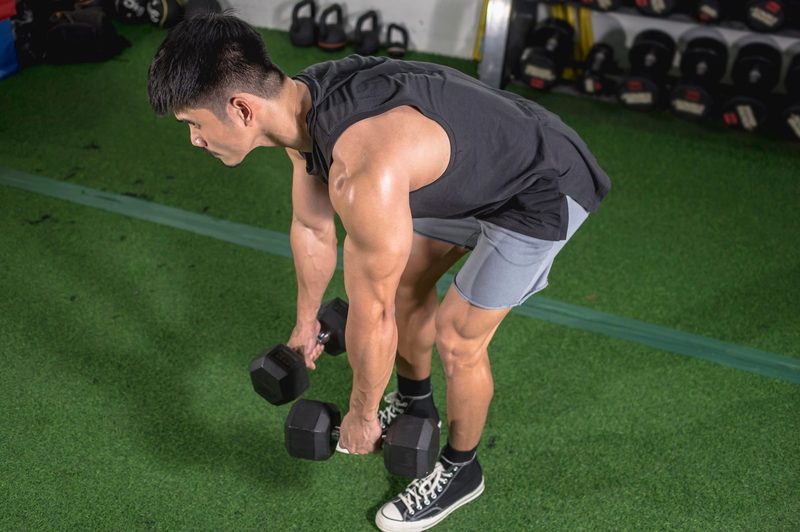 Man does dumbbell Romanian deadlift exercise RDL in gym MDV Edwards Adobe