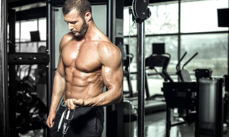 Man in the gym doing cable bicep curls on the cable machine
