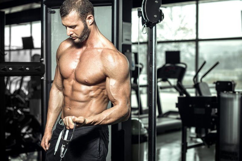 Man in the gym doing cable bicep curls on the cable machine