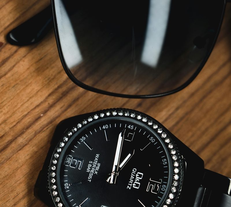 Black watch and sunglasses on table