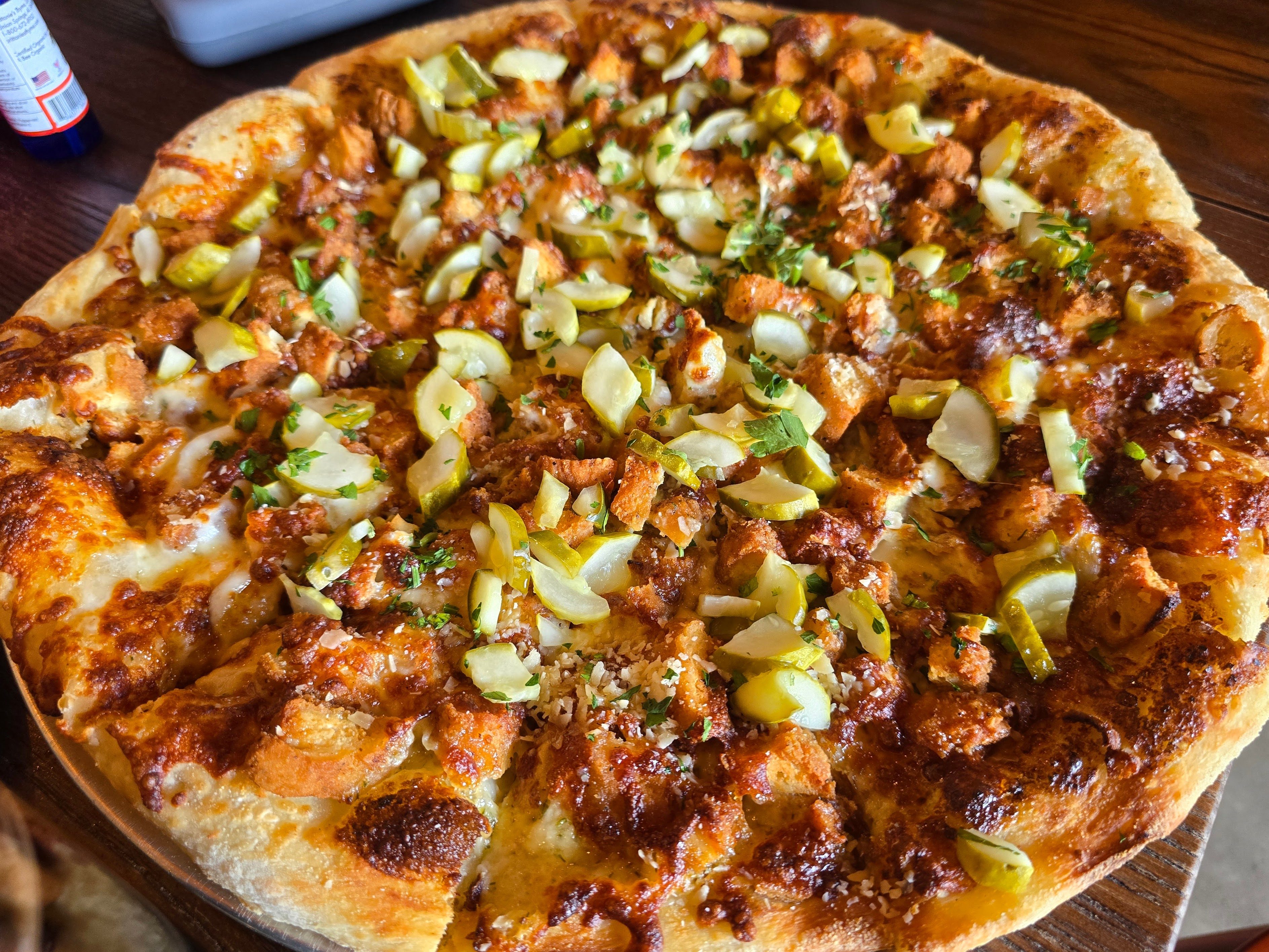 A full pickle and bacon pizza