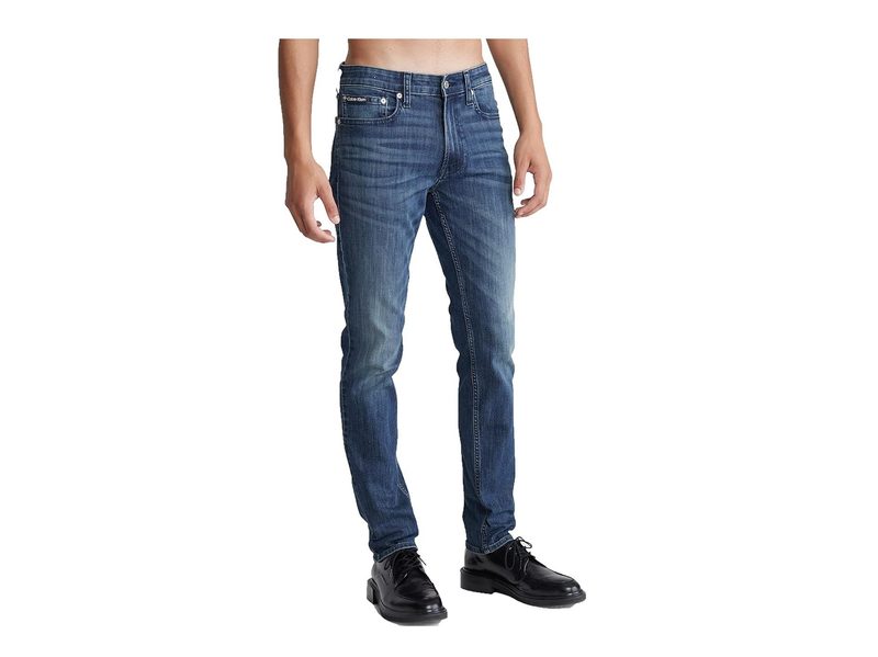 A man wearing Calvin Klein Slim High Stretch Jeans and boots.