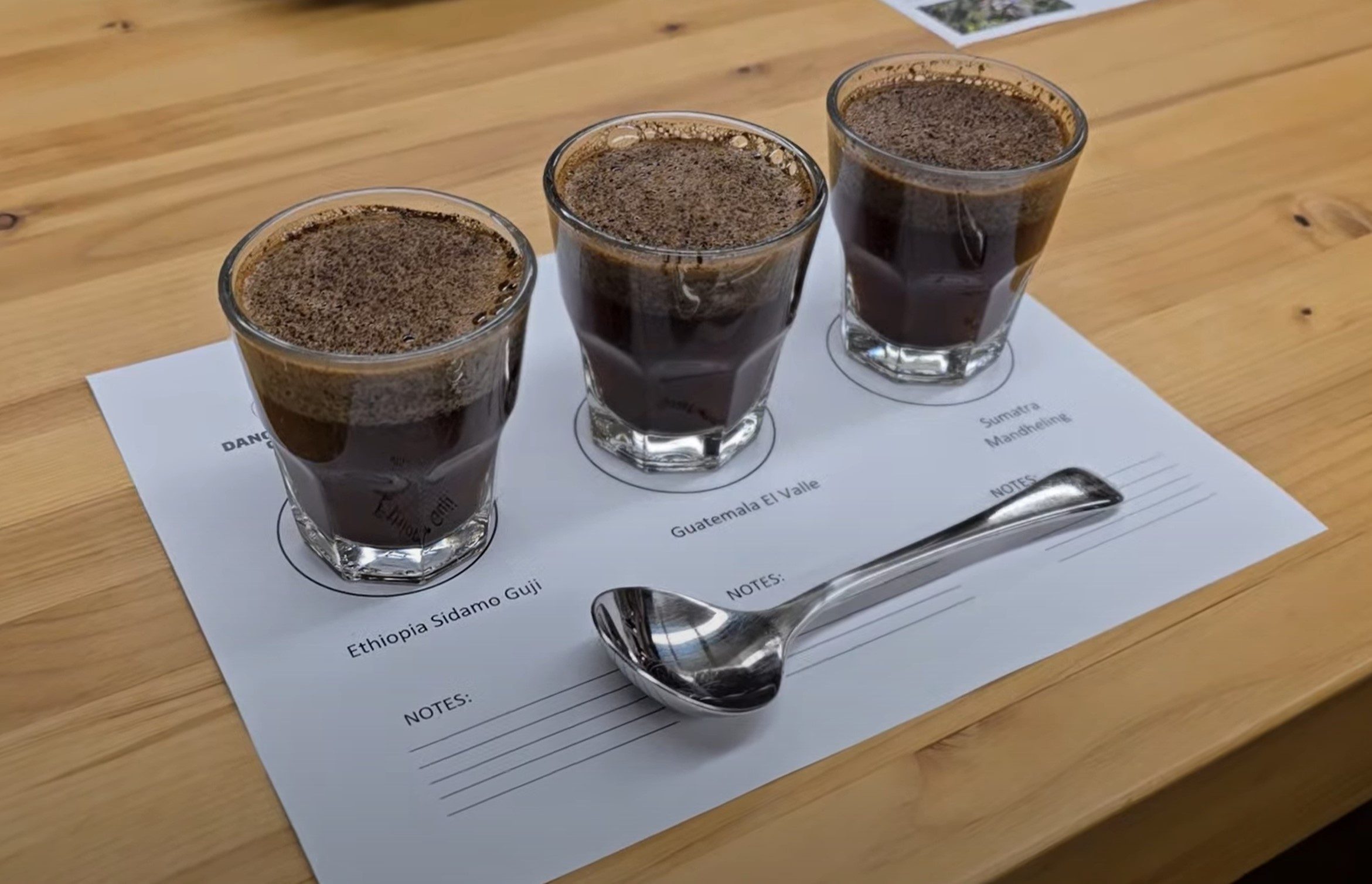 three shot glasses of coffee on a sheet with a spoon
