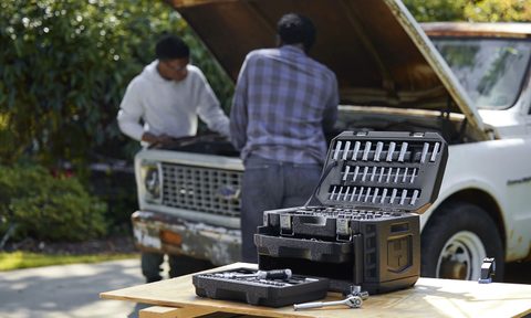 A Hart 215-piece mechanics tool set placed near a car.