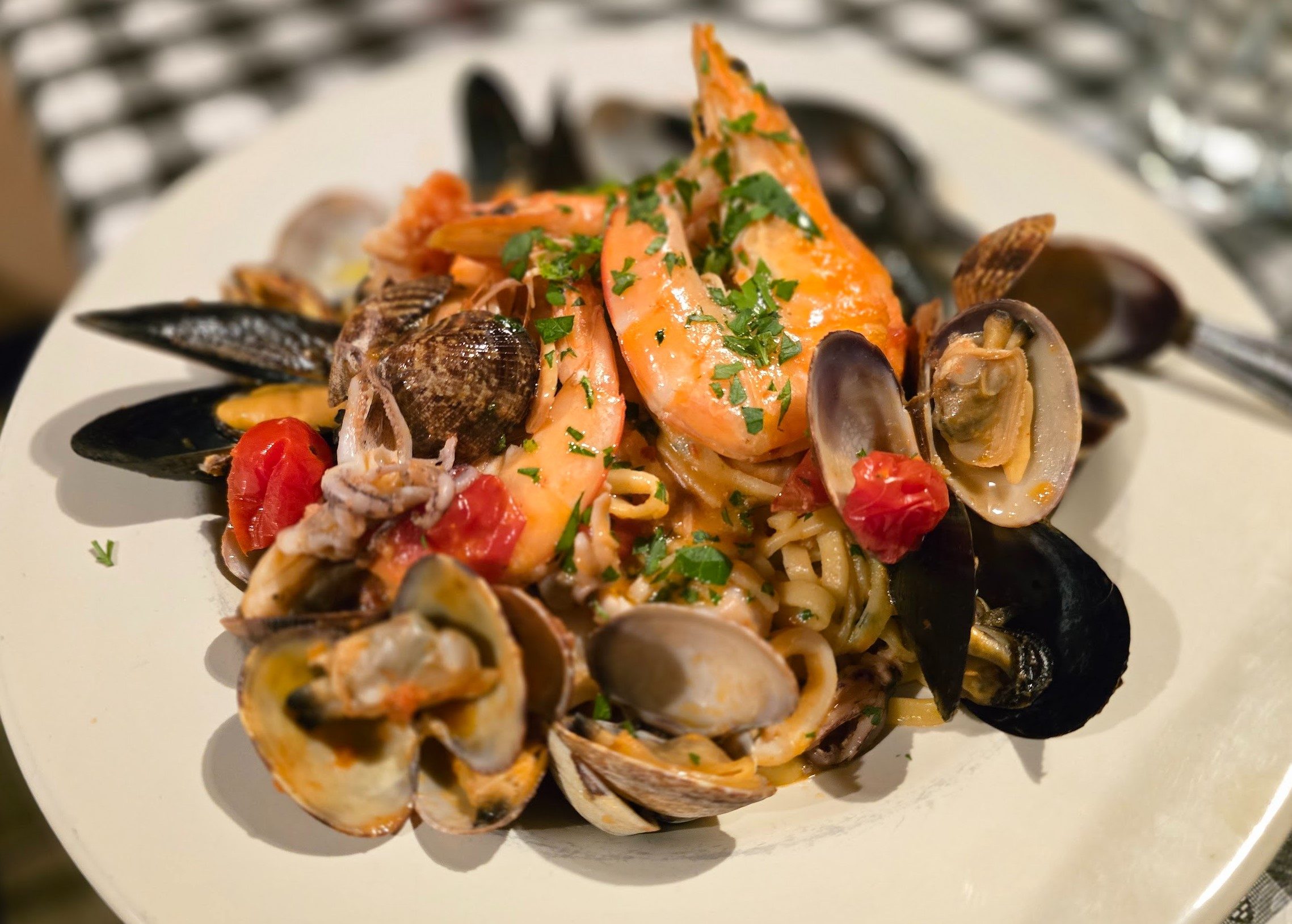 A plate of mixed fish pasta and herbs