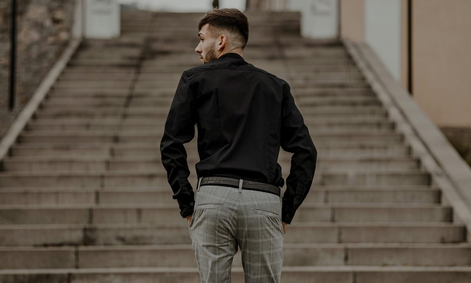 Man in suit pants walking up stairs