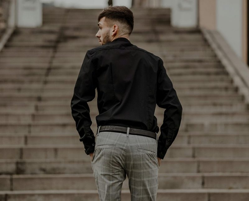 Man in suit pants walking up stairs