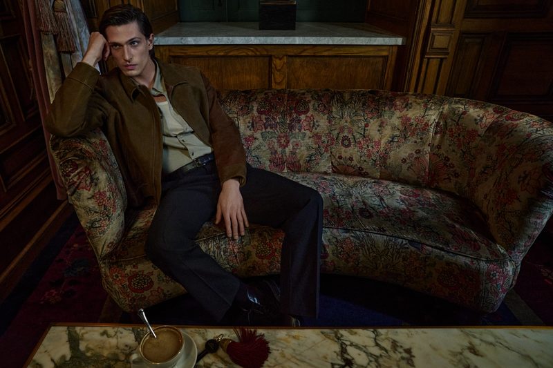 Man sitting on couch in Vince holiday attire