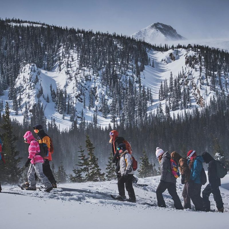 Group of snowshoers snowshoeing in mountainous terrain