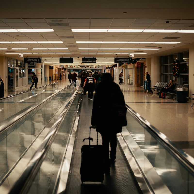 person rolling luggage through airport