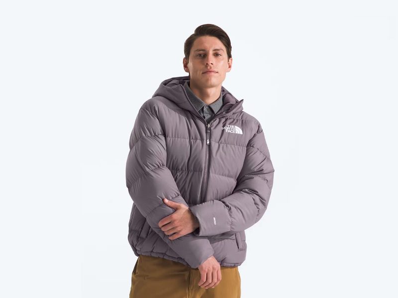 A man strikes a pose while wearing The North Face's Men's Frost Fall Hooded Jacket.