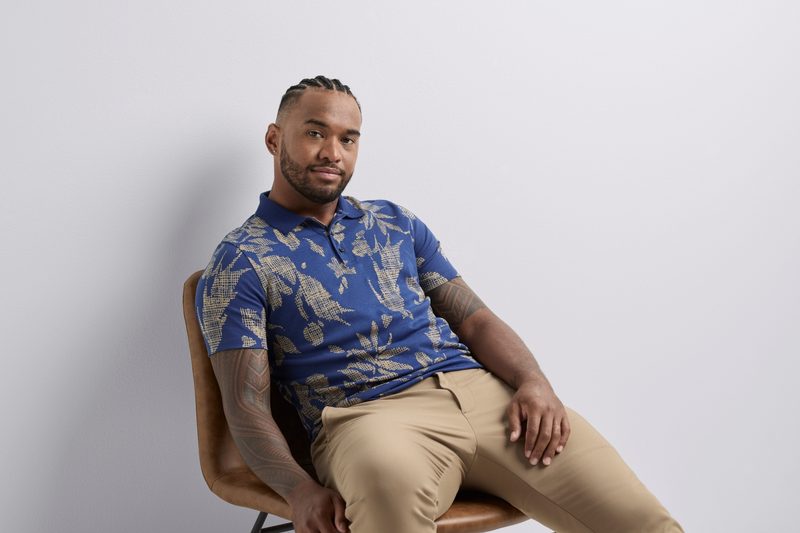 Tua Tagovailoa in a Perry Ellis shirt on chair