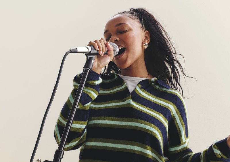 Woman in Gap clothing singing into mic