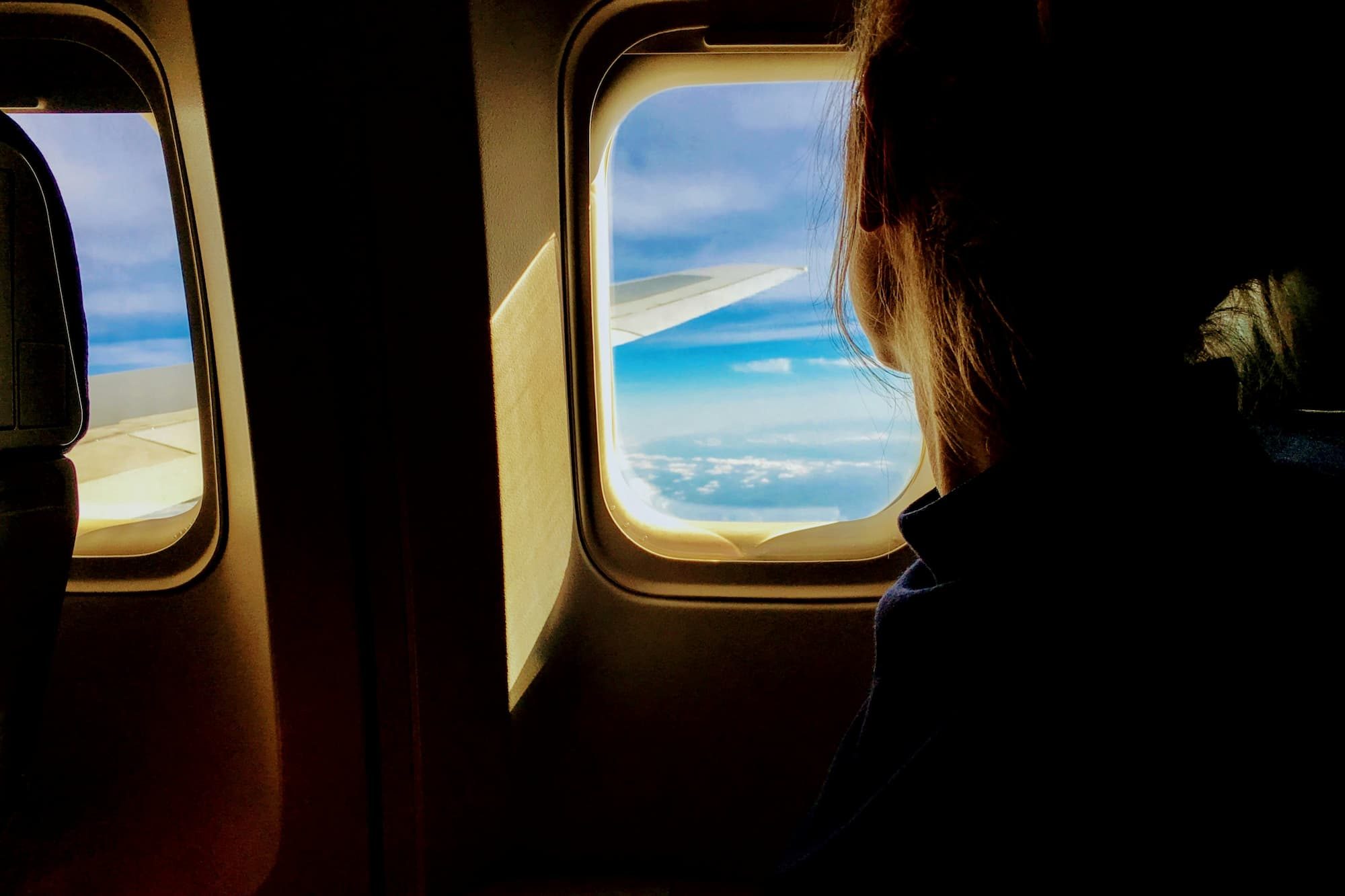 person looking outside airplane window