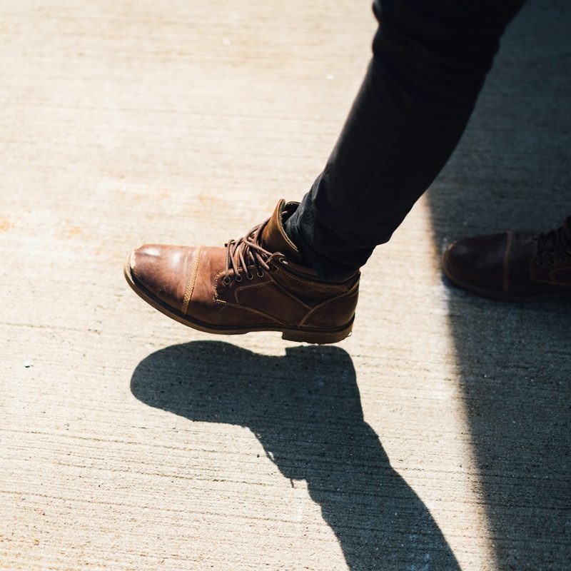 Person wearing brown leather ankle boots