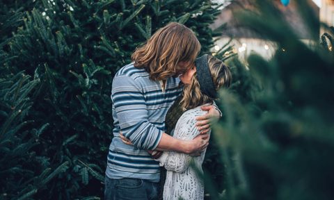 Couple kissing in front of tree