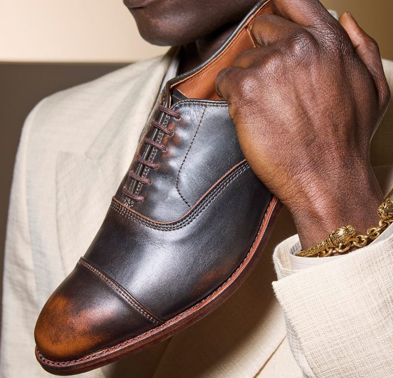 man holding oxford shoe