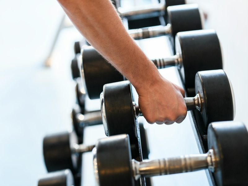 man closeup hand holding dumbbell