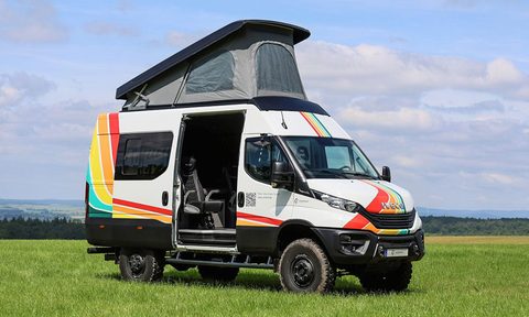 Iveco Daily Switch 4x4 Camper Van parked in a field with the pop-up roof opened.