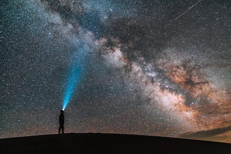 Man stargazing while he hikes at night