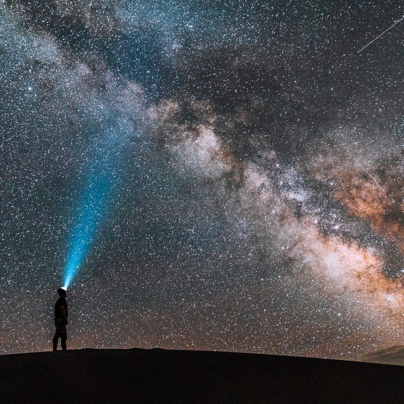 Man stargazing while he hikes at night