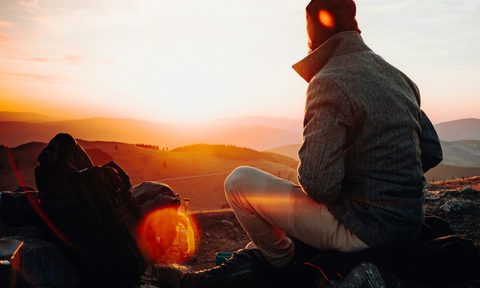 Man sitting outdoors -- Feature for REI Winter Sale early Black Friday event